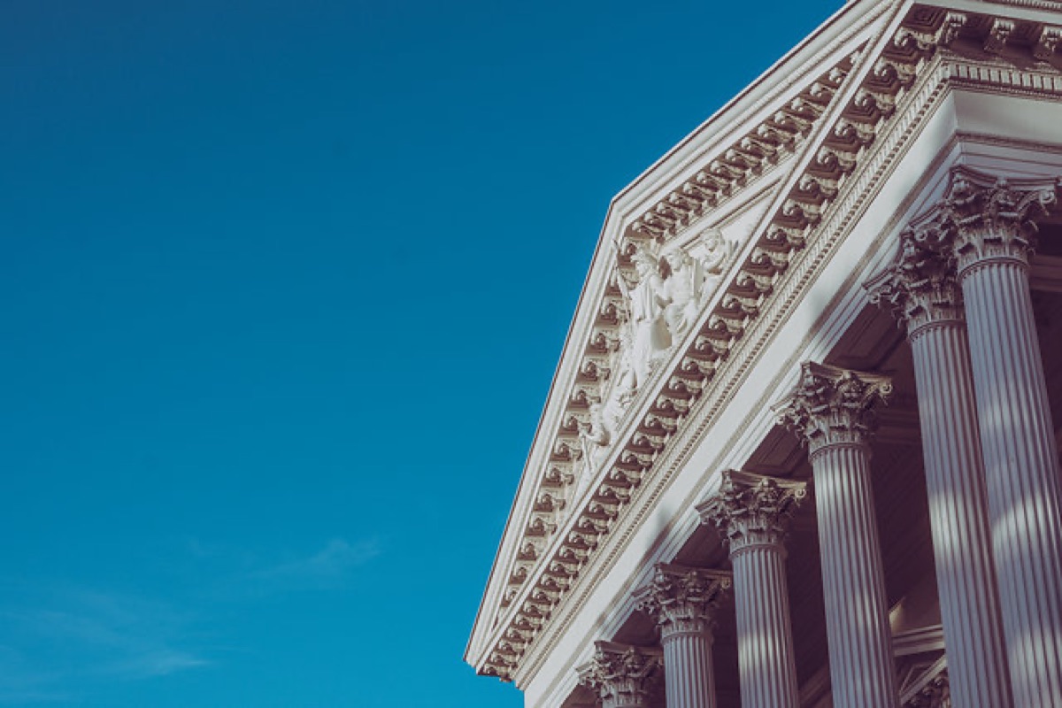Corinthian columns and a carved pediment against a deep blue sky in Sacramento